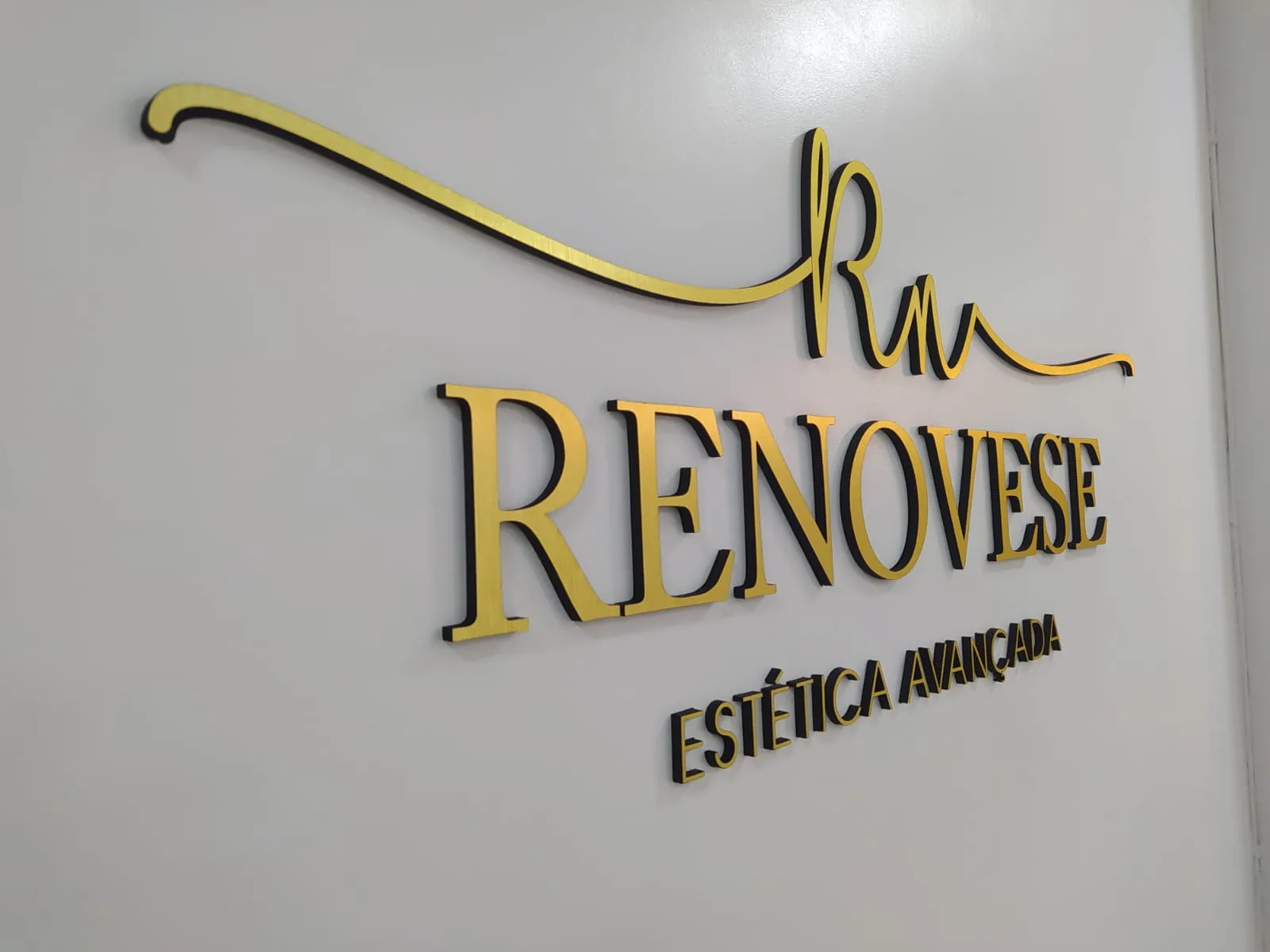 Depois: parede com logo Renovese em acrílico dourado